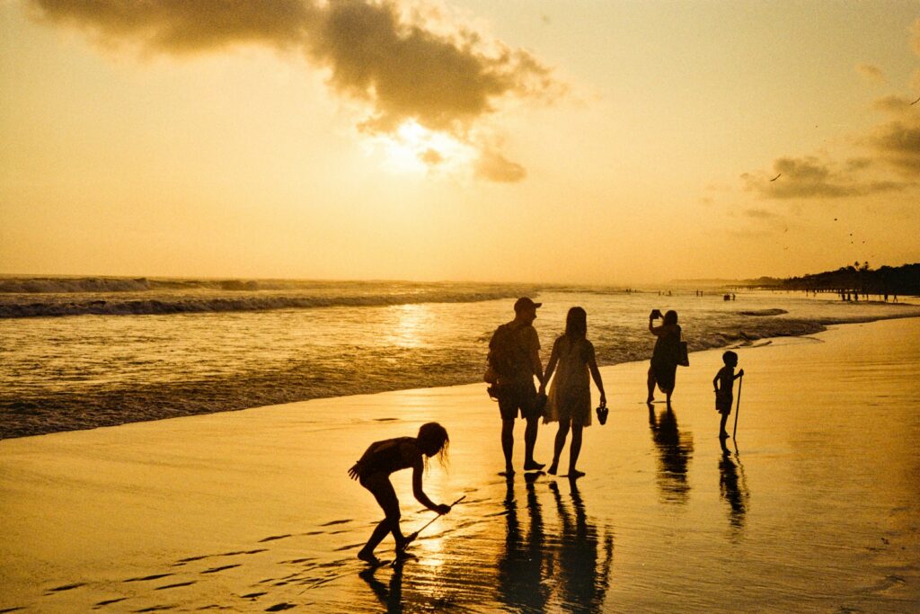 Grandparents and grandchildren watching the sunset on a Caribbean beach